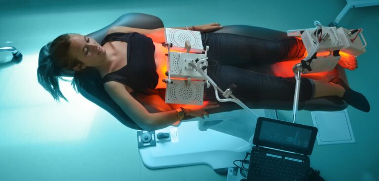 Femme en traitement de photothérapie, allongée sous une lumière rouge.