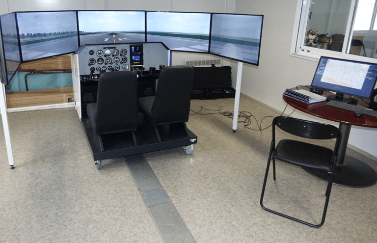 Simulateur de vol avec cockpit et écrans affichant une piste d'atterrissage.