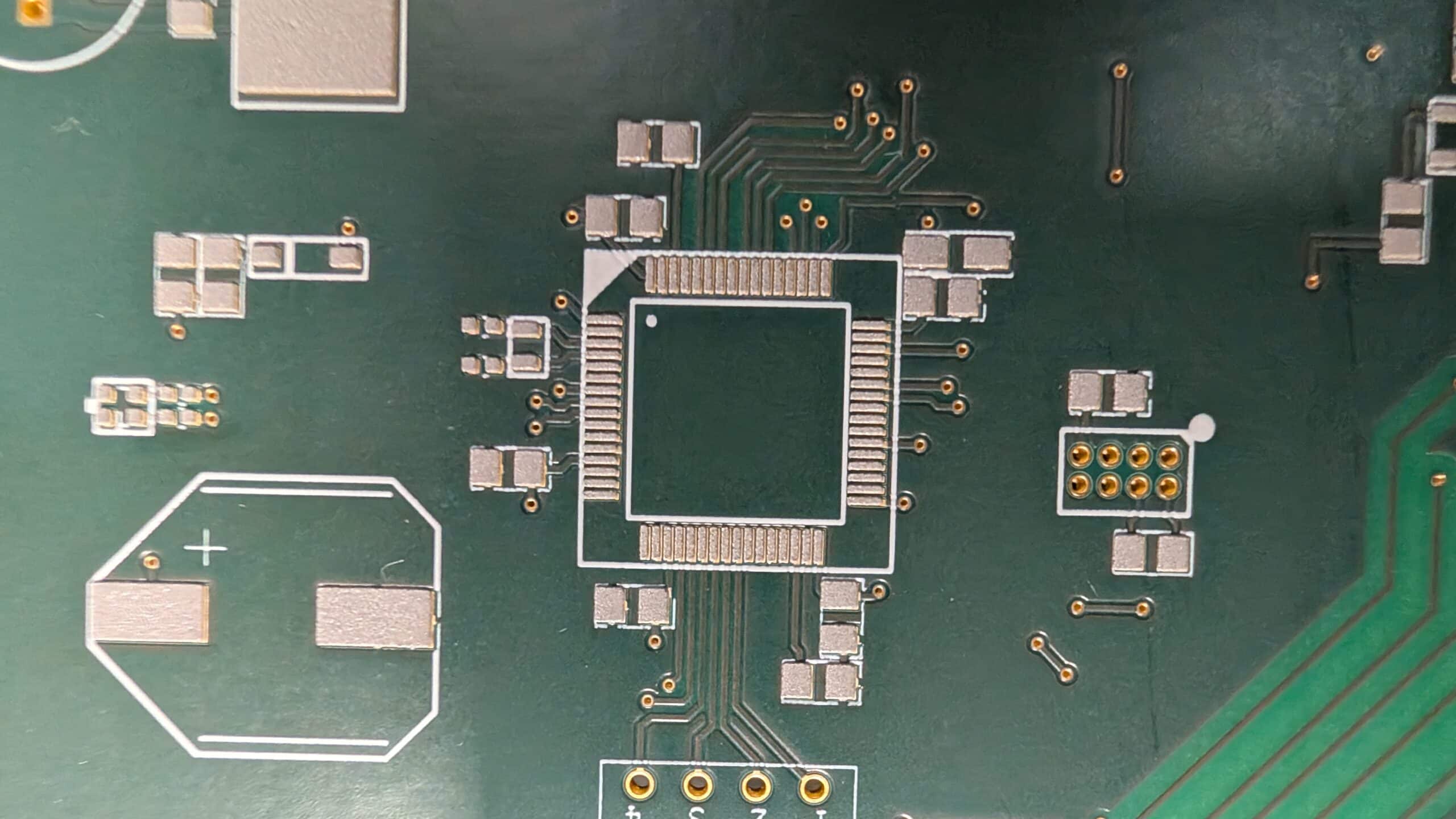 Prototype de carte électronique avec une puce centrale et des composants montés en surface.