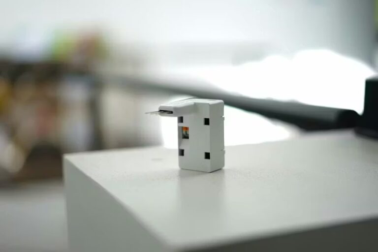 Petit interrupteur blanc Monabee sur une surface claire.