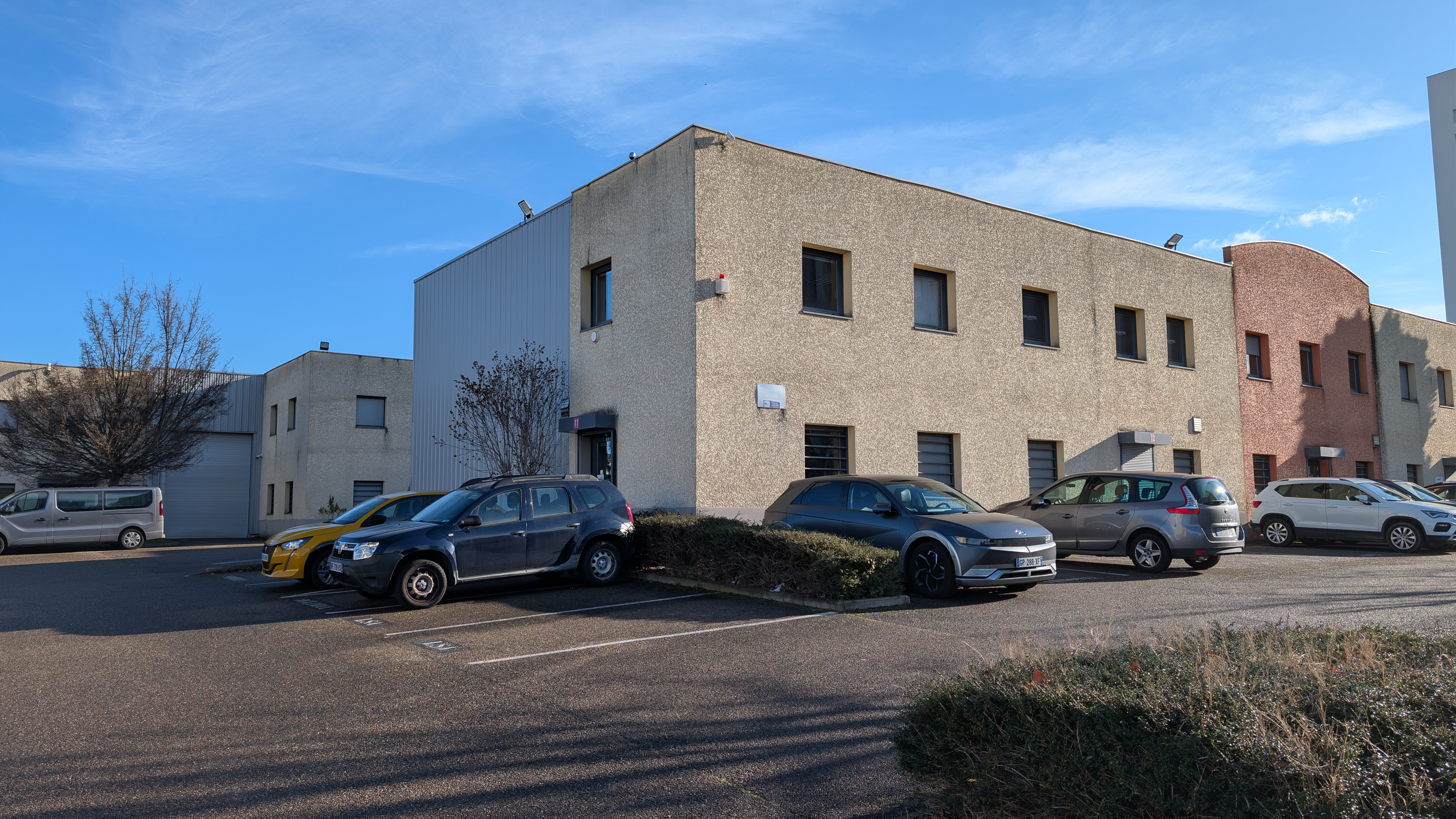 Voitures garées devant un bâtiment d'affaires.