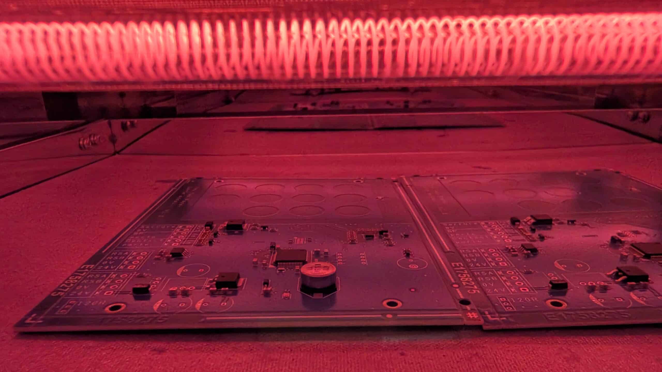 Prototypes de cartes électroniques sous lumière rouge, composants électroniques visibles. E1758275.