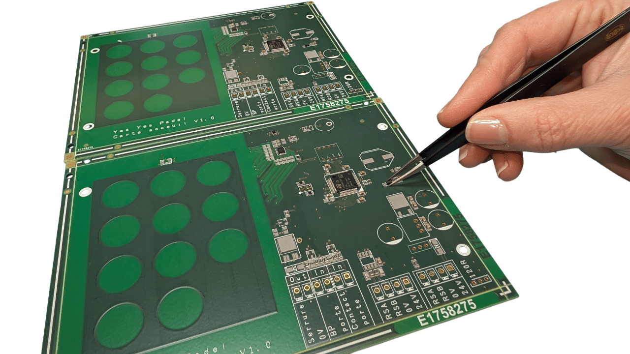 Prototypes de cartes électroniques vertes manipulées avec des pinces de précision.